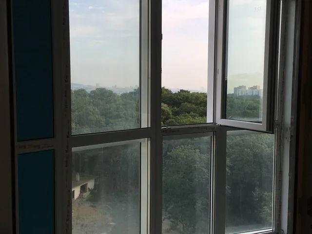 Пластиковое окно с открытой створкой, вид на сопки